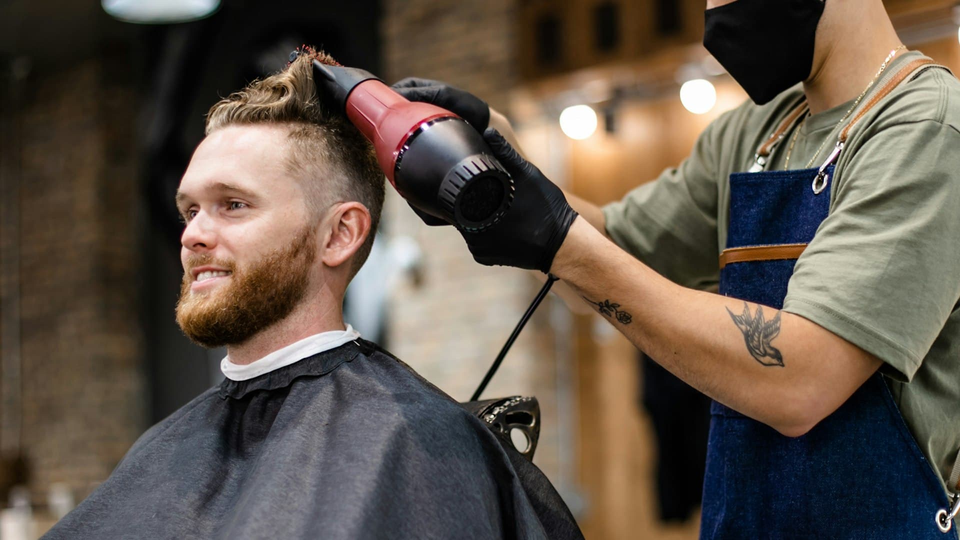 Barbero cortando el cabello a un cliente en una barbería