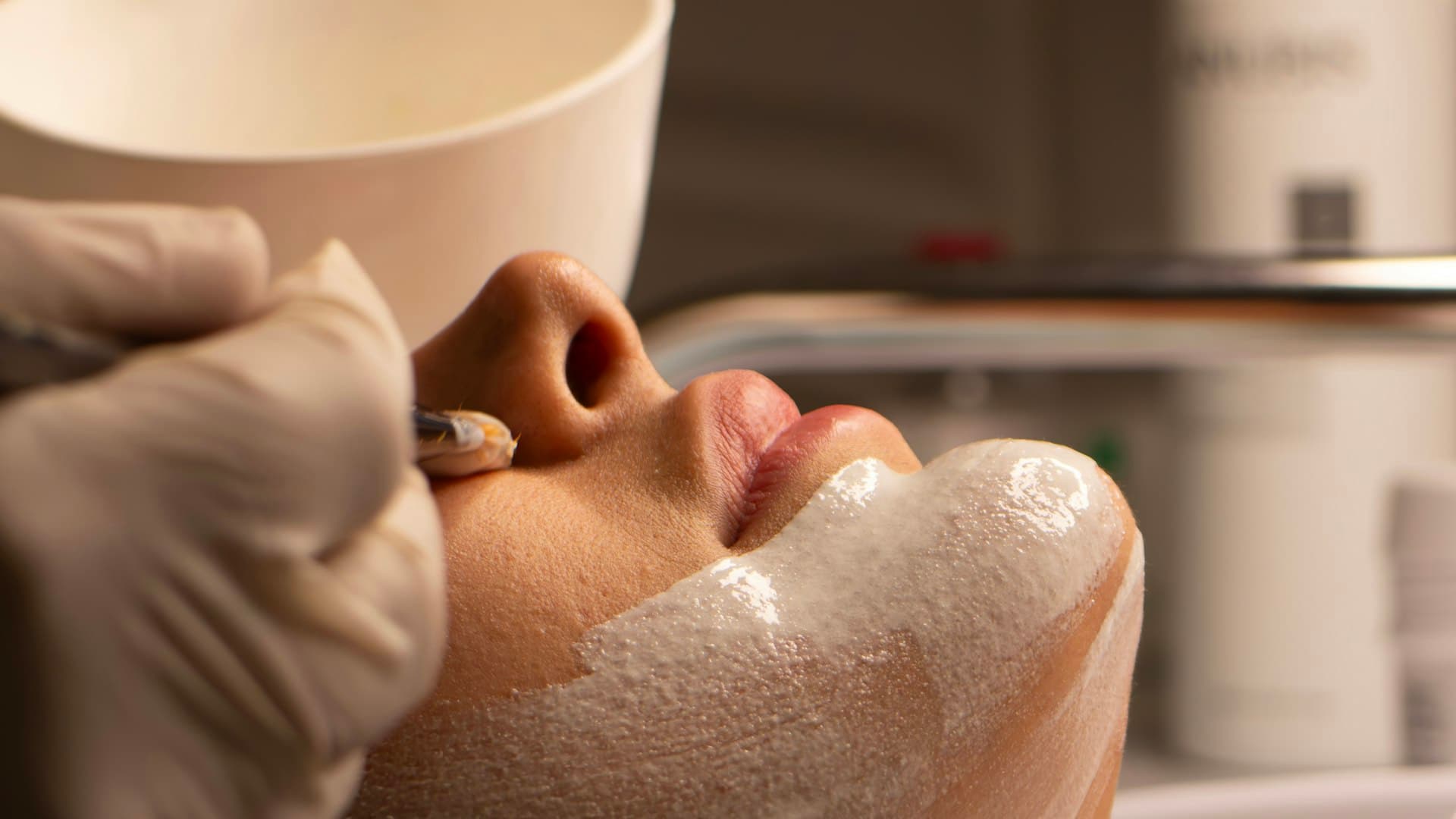 Especialista aplicando un tratamiento facial a una clienta