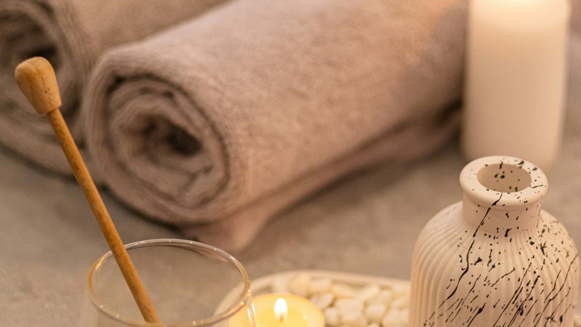 Mesa de masaje con velas y toallas en un spa